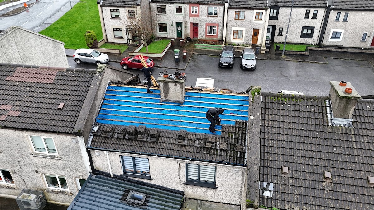 Drone view over a row of house roofs with fresh blue membrane being fitted